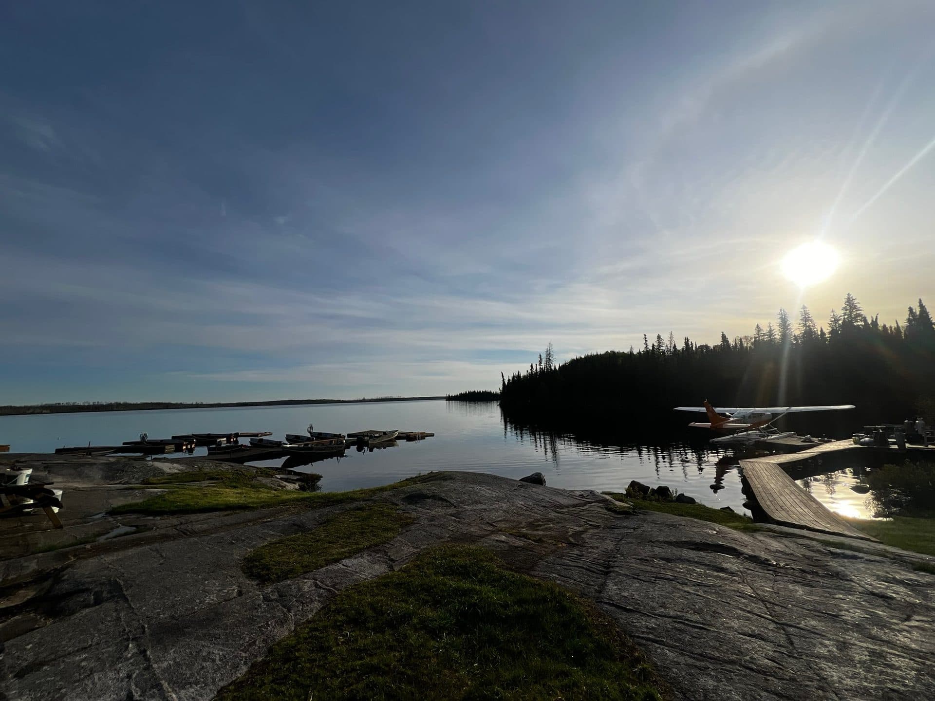 Dogskin Lake Lodge dock with boats and floatplane at golden hour