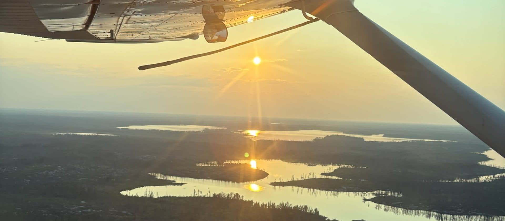 Boreal forest island reflected in glass-calm water on Dogskin Lake