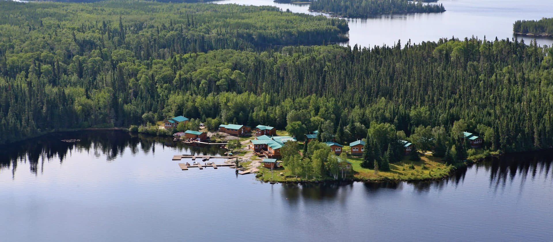 Guests gathered for shore lunch on Dogskin Lake with boats and boreal forest